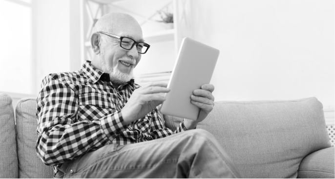 Photo of a mature gentleman smiling at his iPad