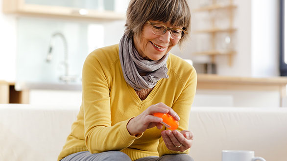 A woman smiles while taking her medication.