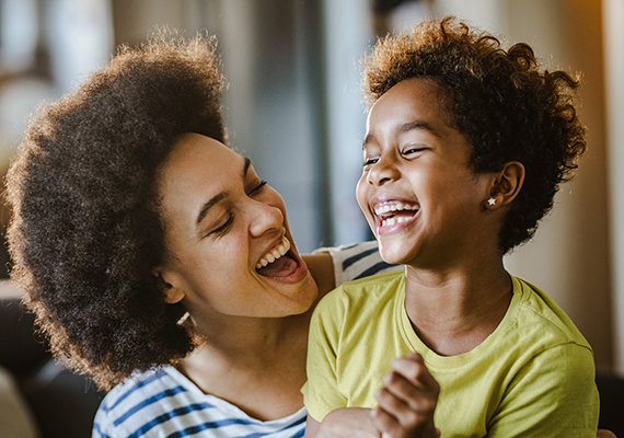 A mother and child smile and laugh.