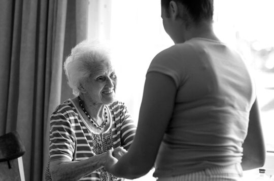 Caregiver helping older woman