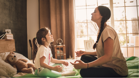 A mother and daughter meditate together