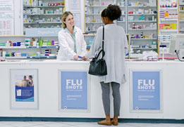 A photo of a woman at a pharmacy counter.