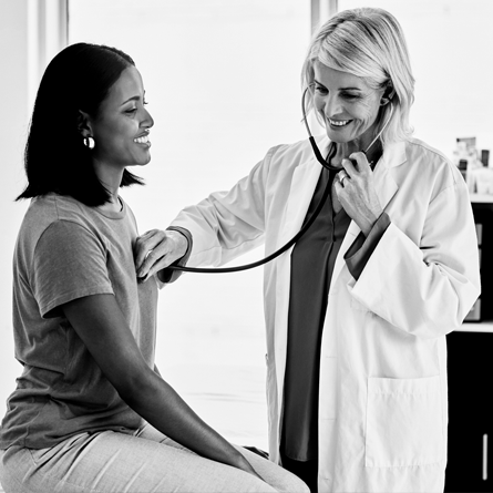 Person being examined by physician with stethoscope 