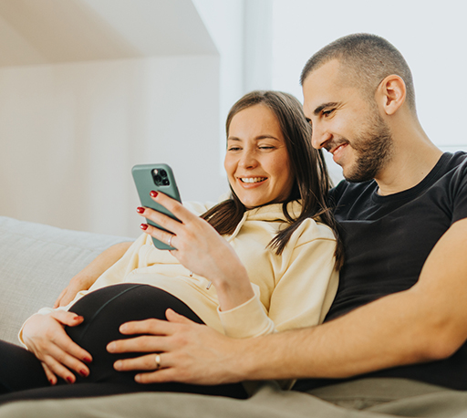 Man and pregenant woman looking at a smart phone