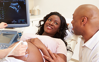 A pregnant woman and her partner get an ultrasound.
