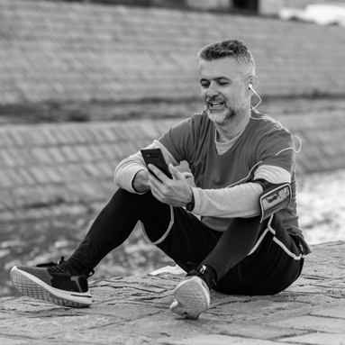 A man sits on the ground and talks on his phone