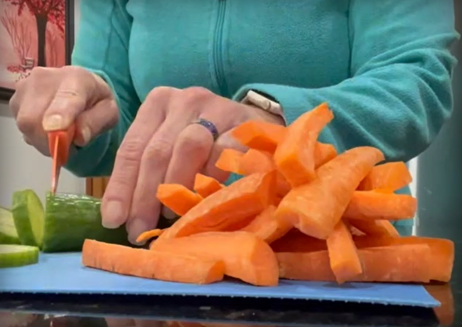 A woman chops some healthy vegetables. 