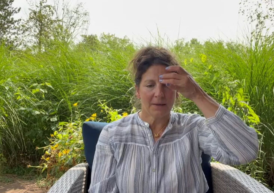 A woman taps her forehead. 